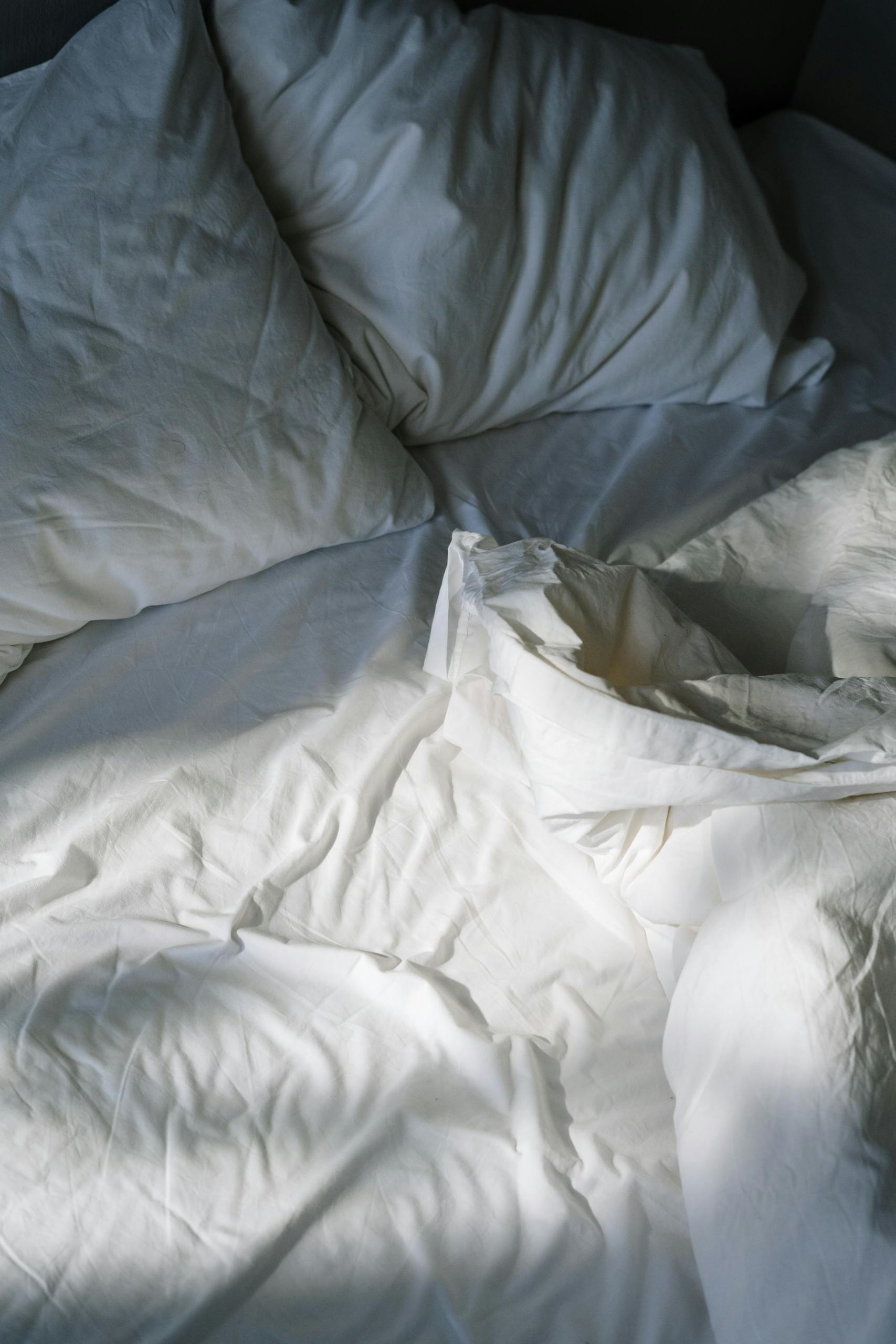 A cozy bed setting with soft blankets and pillows, perfect for learning how to stop bed rotting and practise self-care.